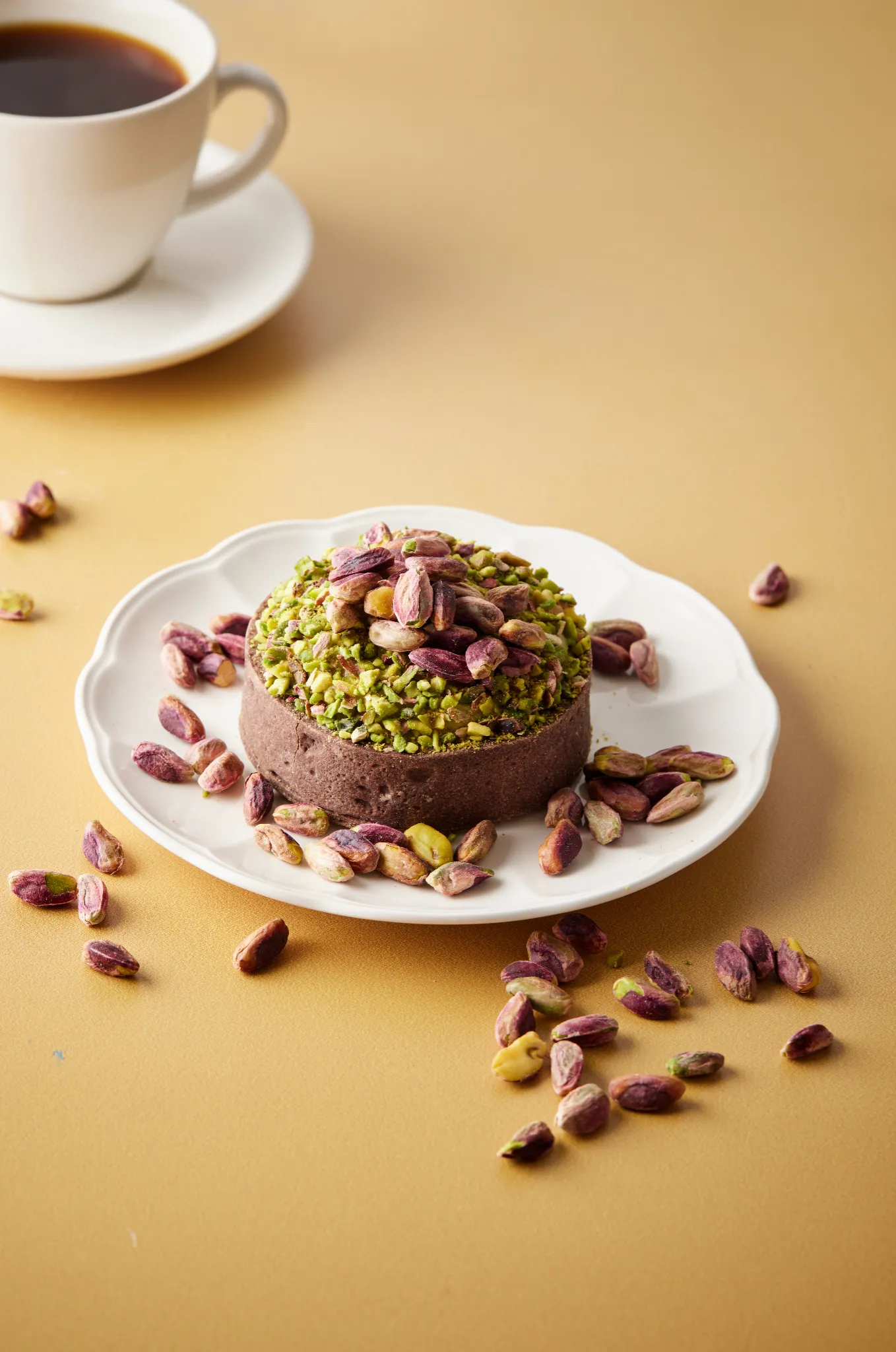 Food styling Atlanta — pistachio dome dessert with scattered nuts on warm backdrop