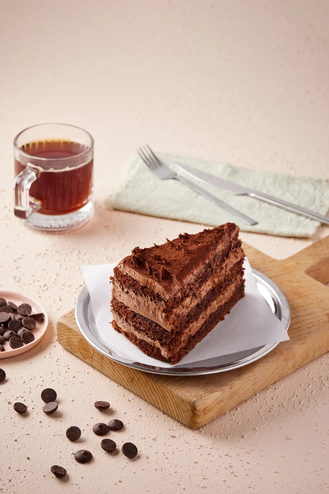 Food stylist Atlanta — chocolate layer cake slice with tea on wood board