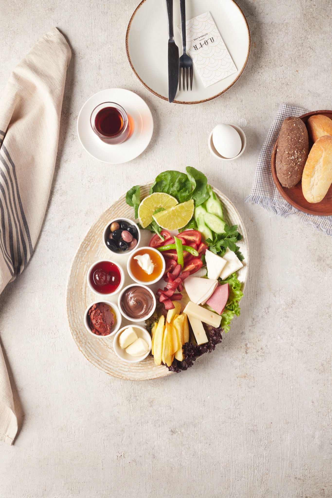 Top-down Turkish breakfast plate with dips, cheeses, fries and Turkish tea – Atlanta restaurant photography.