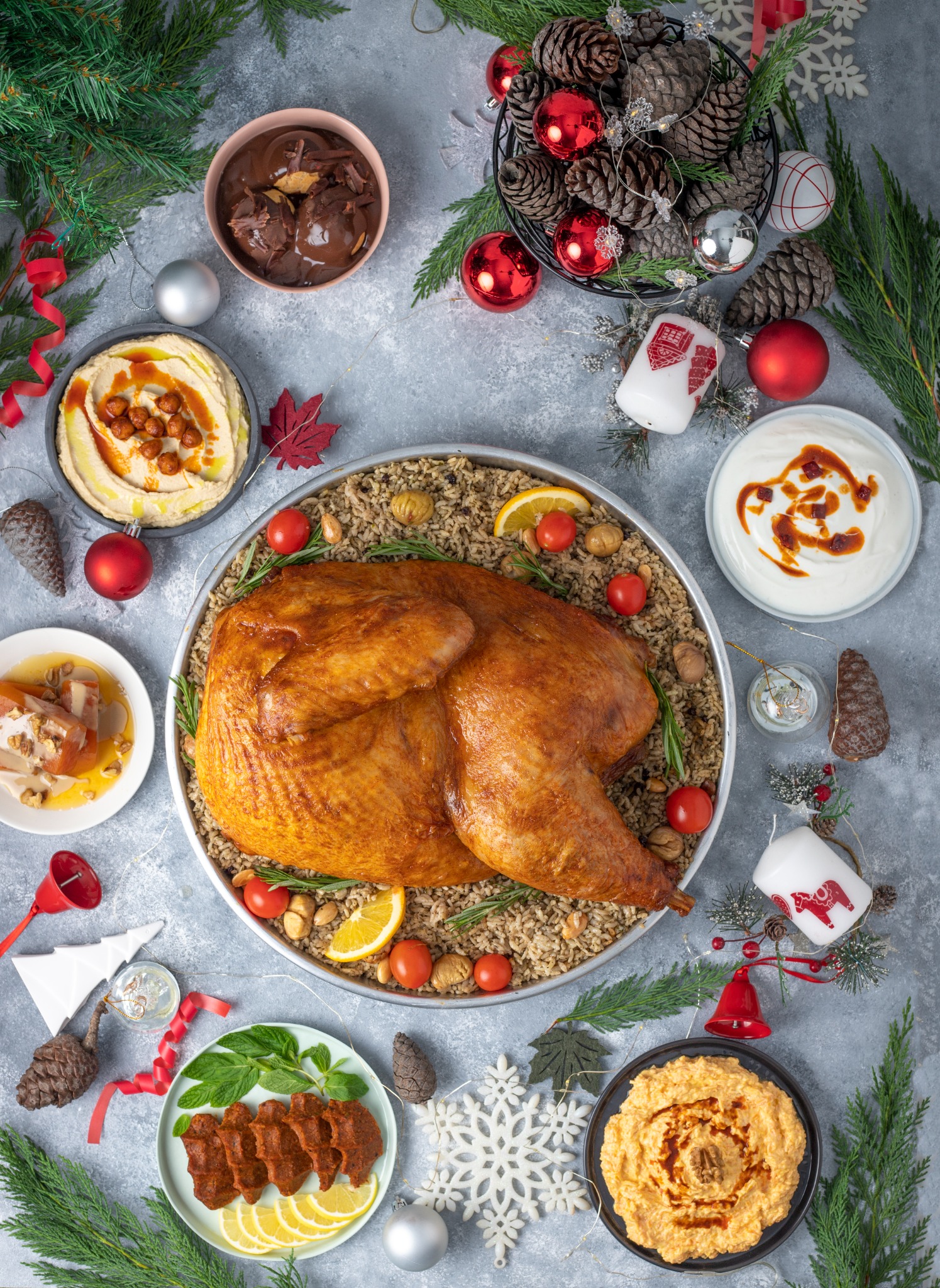 Holiday roasted turkey with meze plates and ornaments – overhead composition.