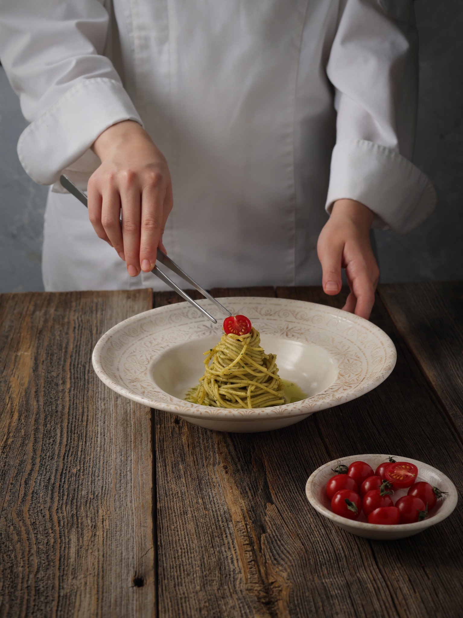 Chef styling pesto spaghetti with tongs – restaurant food styling in Atlanta.